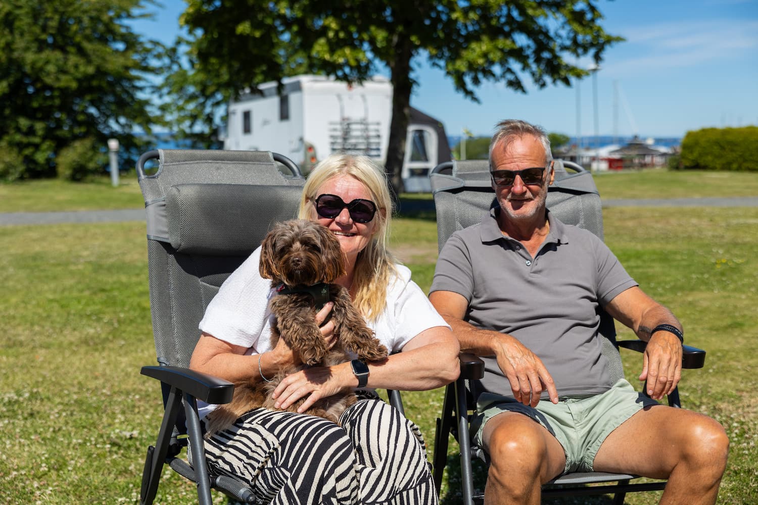 Husbilsgäster med hund njuter av en härlig dag på campingen i Småland
