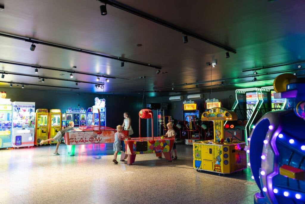 Inifrån spelhallen där barn spelar airhockey på Skara Sommarland camping